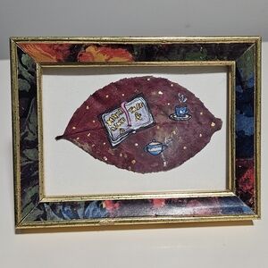 Artistic Leaf Painting Featuring a Book, Tea And Tea Kettle In A Vintage Frame